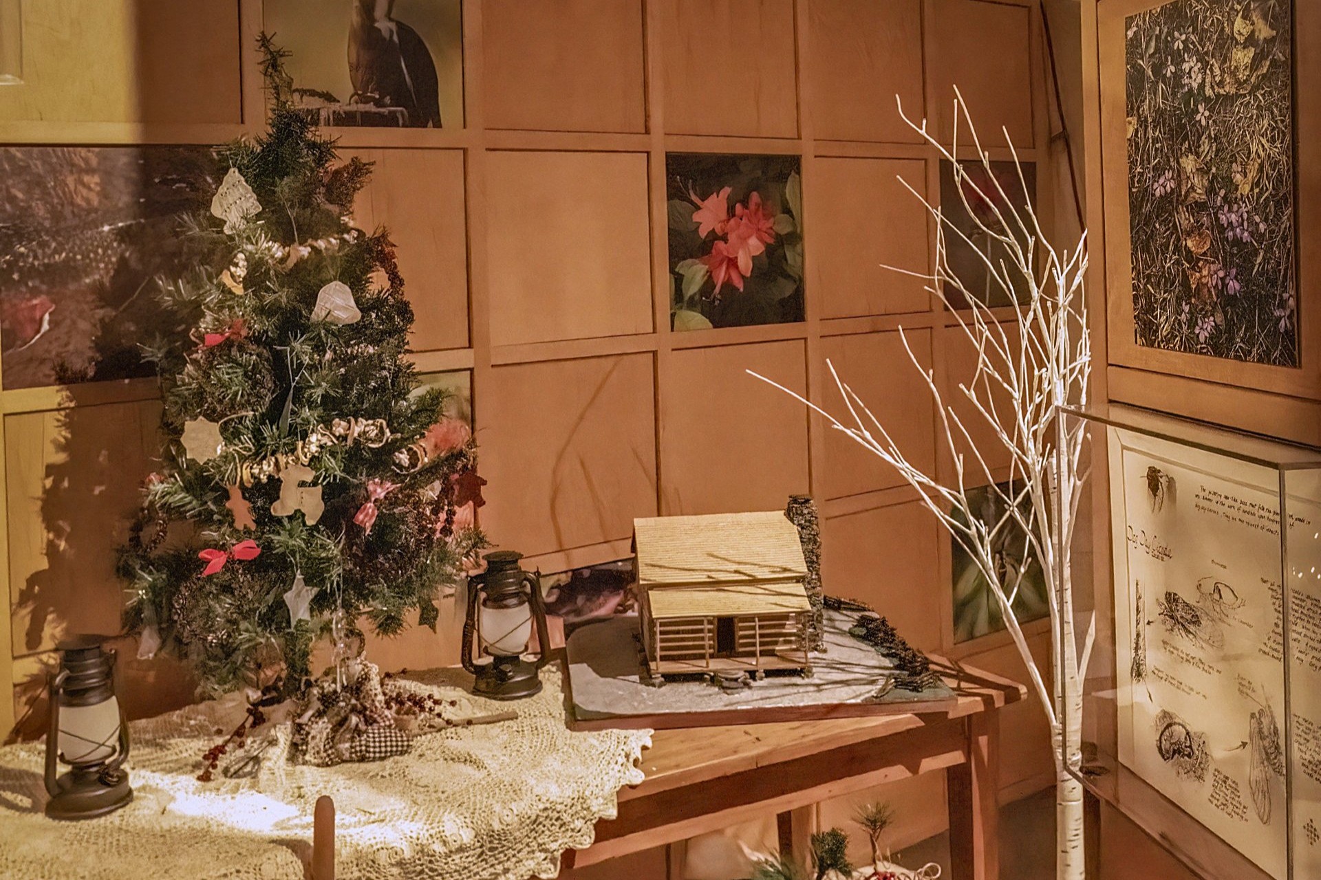 A Christmas tree on a table surrounded by holiday decor.