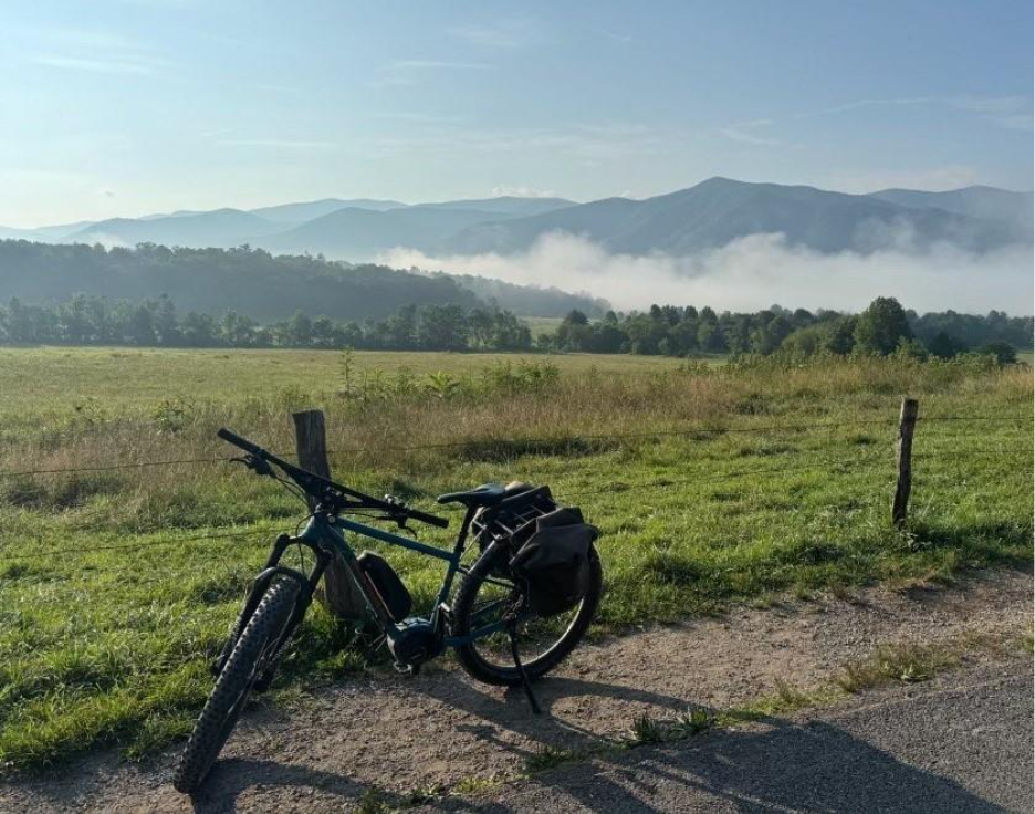 ebike on Cades Cove Loop Road with mountains and a field in the background