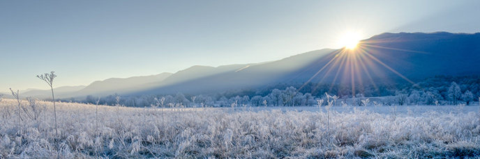 The sun rises over the mountains on a frosty winter morning in Cades Cove. The sun rises over the mountains on a frosty winter morning in Cades Cove.