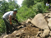 Crew uses rockbars to move rock