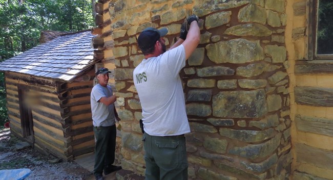Historic preservation crew works on chimney at Elijah Oliver cabin.