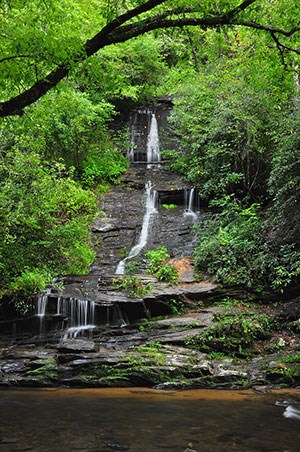 Thin ribbon of water falls over exposed rocks at Tom Branch Falls in Deep Creek