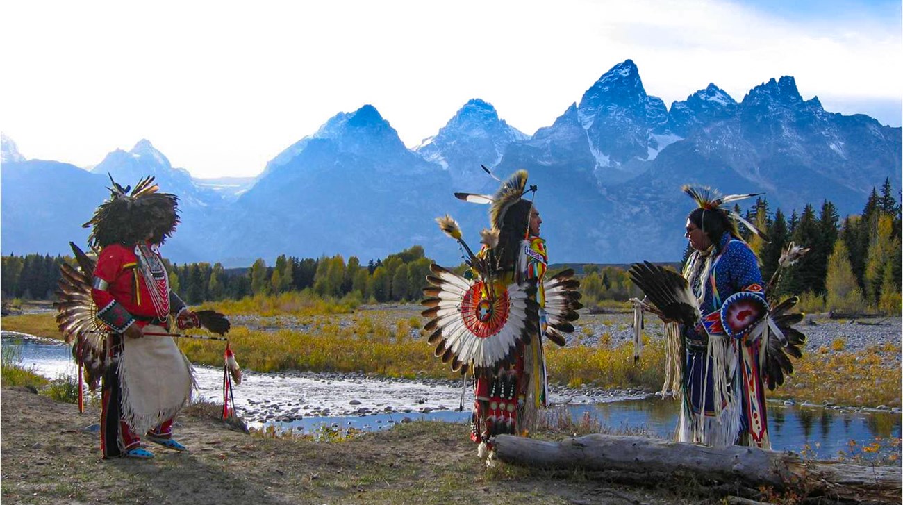 Shoshean dancers in traditional dress with Teton Range in background