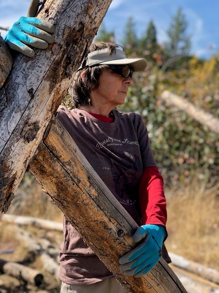 A trails volunteer removes fencing