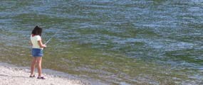A young girl fishing on the Snake River at the Jackson Lake Dam. A young girl fishing on the Snake River at the Jackson Lake Dam.