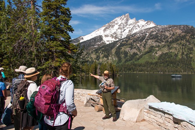 Ranger with visitors at Lakeshore overlook of Jenny Lake and Mount Teewinot above the lake