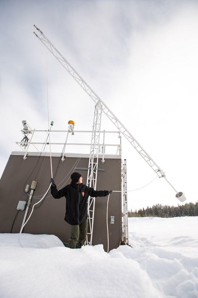 A hydrologist adjusts an ozone monitoring instrument.