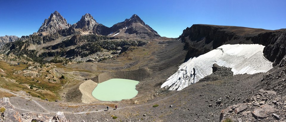 Schoolroom glacier with crevasses above small lake and terminal moraine.