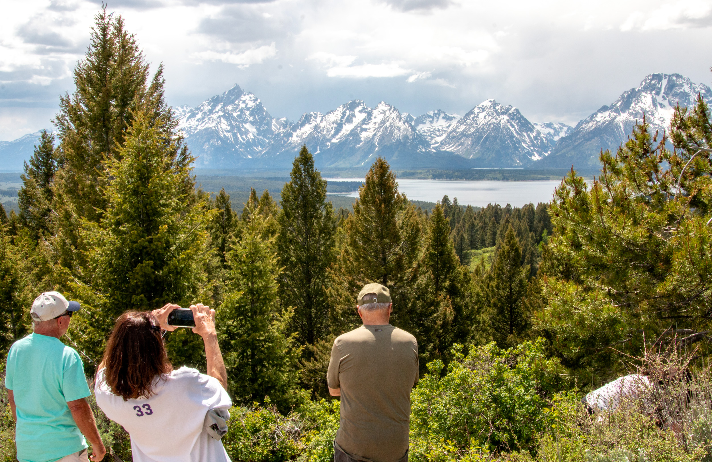 Visitors taking photos of the Teton Range atop Signal Mountain in Grand Teton National Park