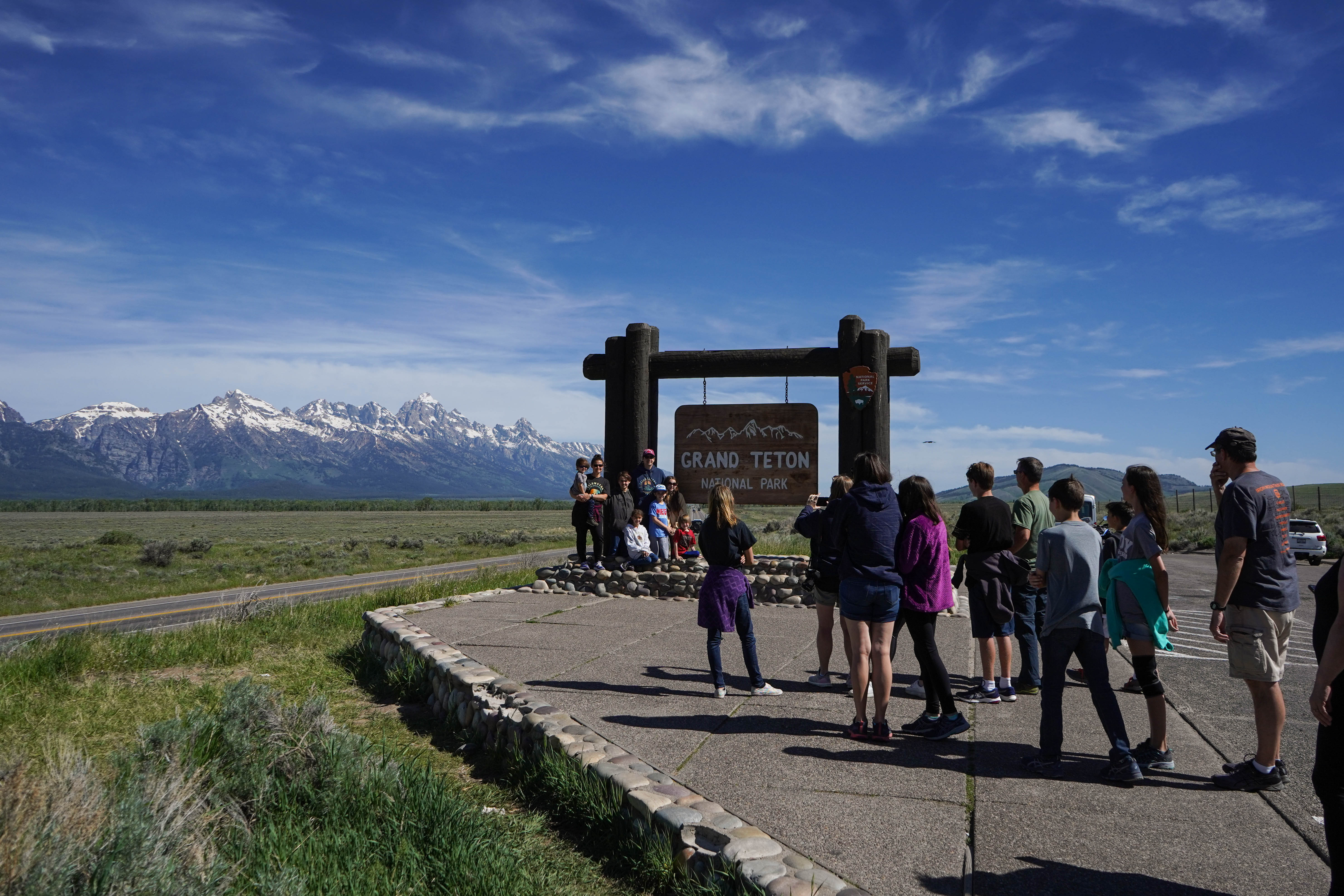 groups of people by a Grand Teton sign