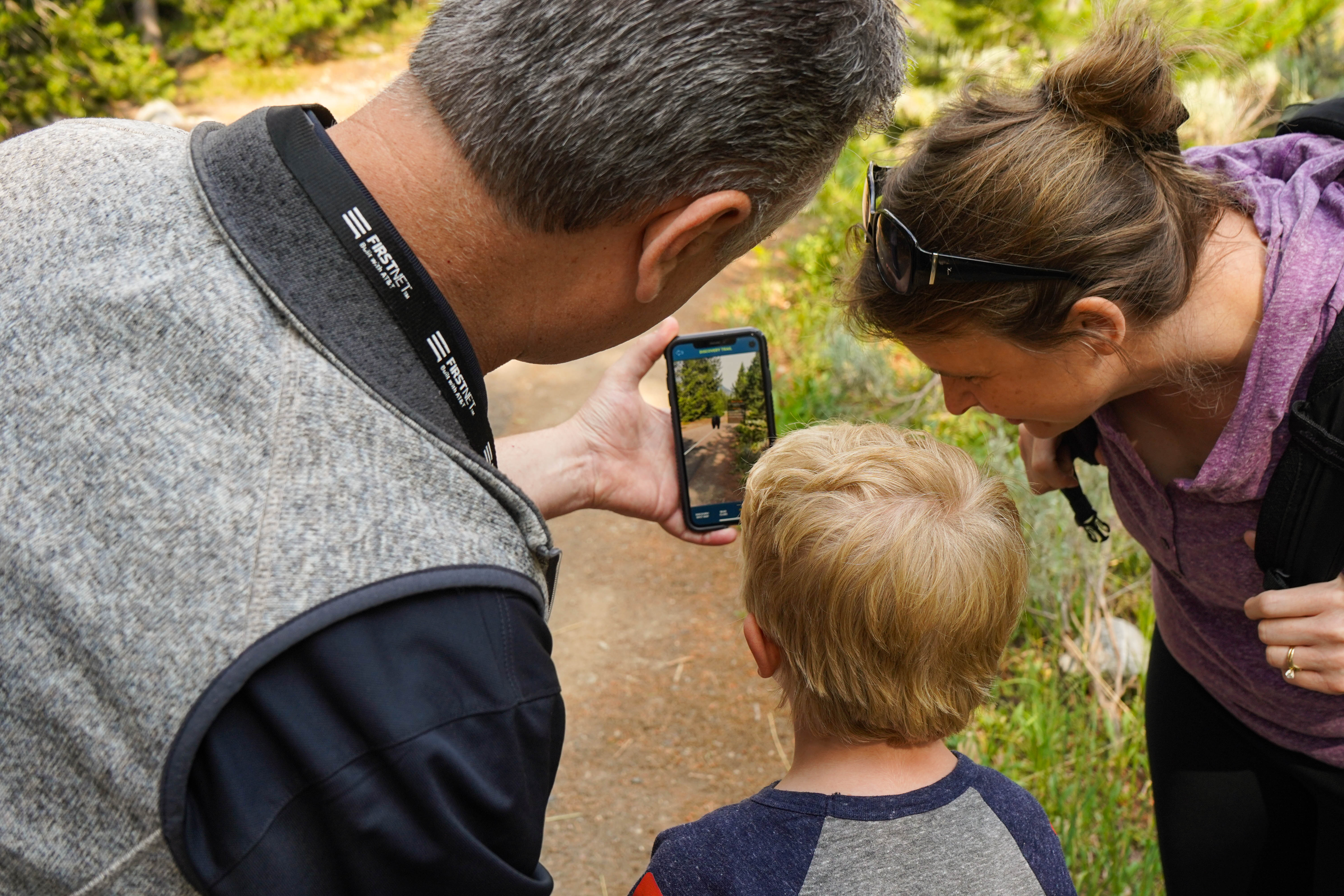 Junior ranger and junior rangers at heart use Jenny Lake Explorer app to find augmented reality animals along the Discovery Trail