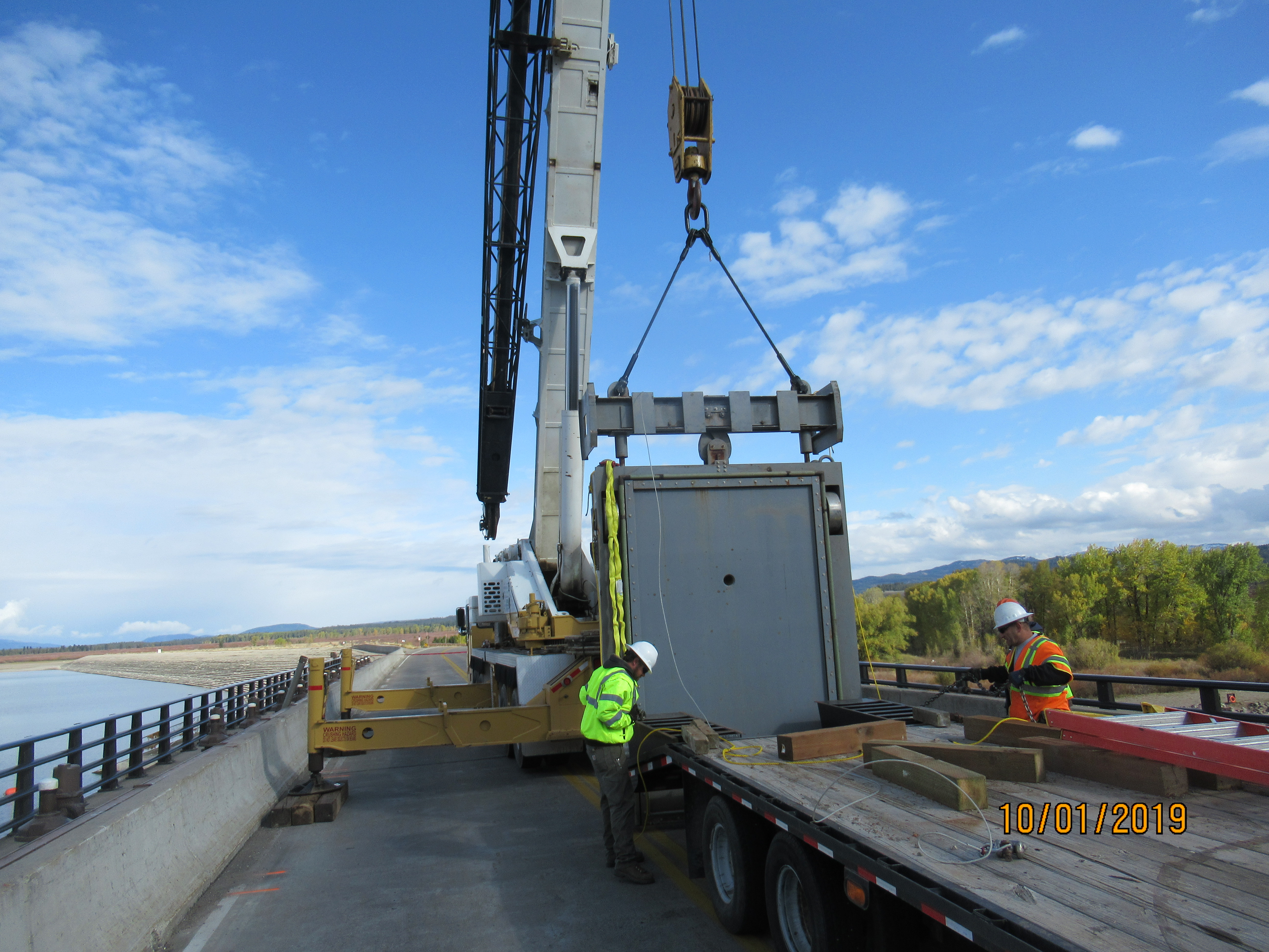 Crane work taking place to set and move the bulkhead gate to inspect and perform maintenance work on multiple reservoir release gates at the Jackson Lake Dam.