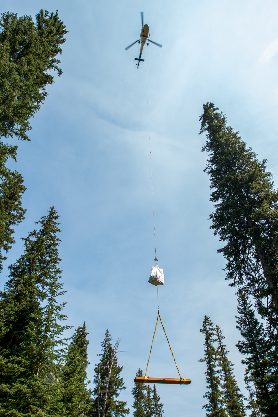 Helicopter transports heavy materials to backcountry trail location