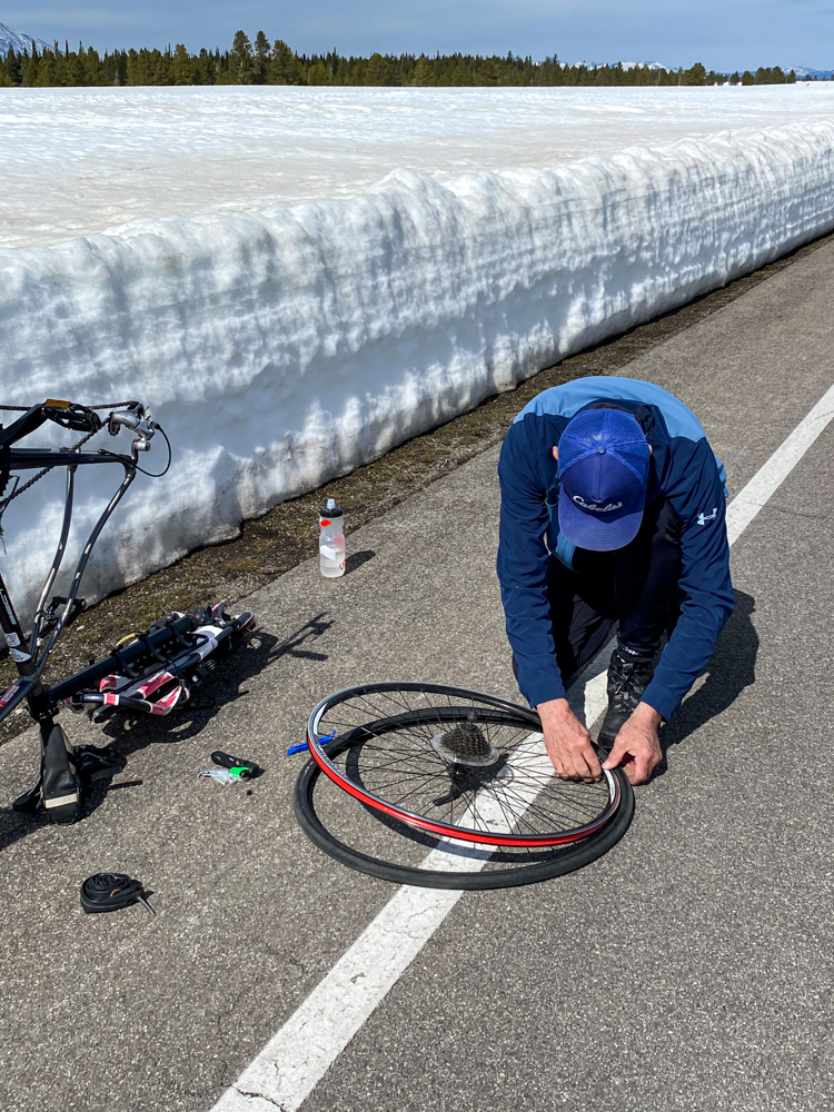 Visitor makes repairs to bicycle along the Teton Park Road.