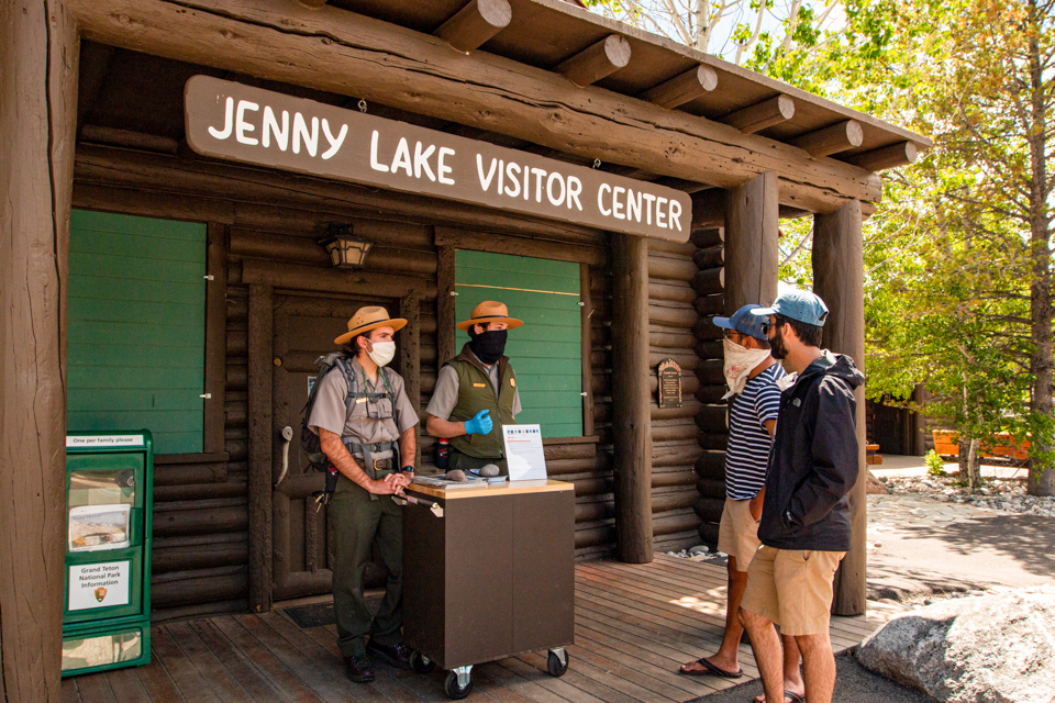 two interpretive rangers give information to park visitors near the Jenny Lake Visitor Center