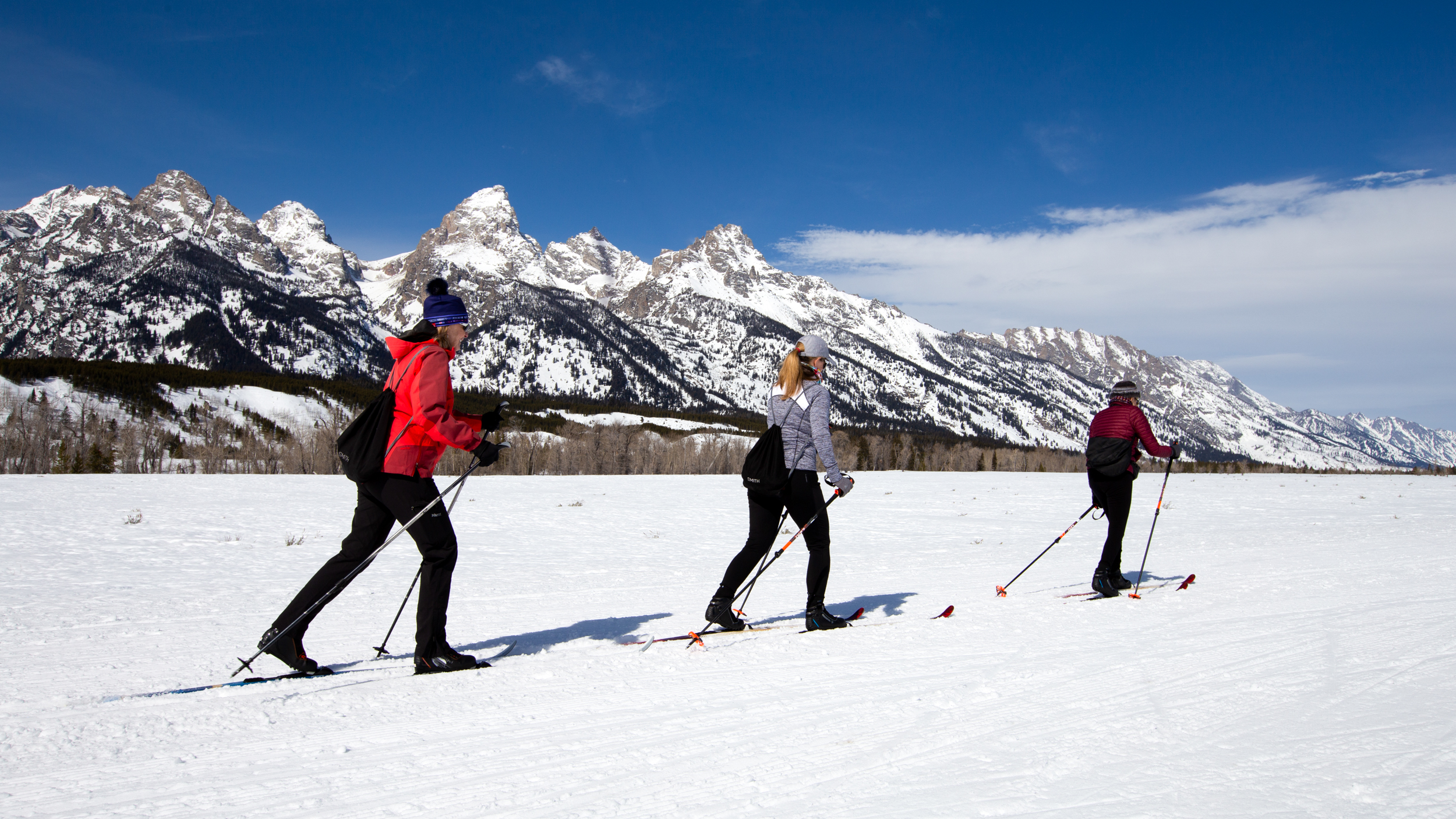 Cross-country skiers on the Teton Park Road Cross-country skiers ski the Teton Park Road with the snowy Teton Range behind