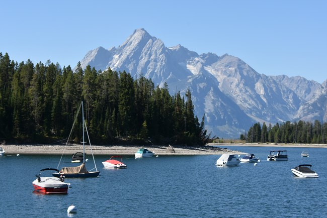 Boats in a marina with a mountain in the background.