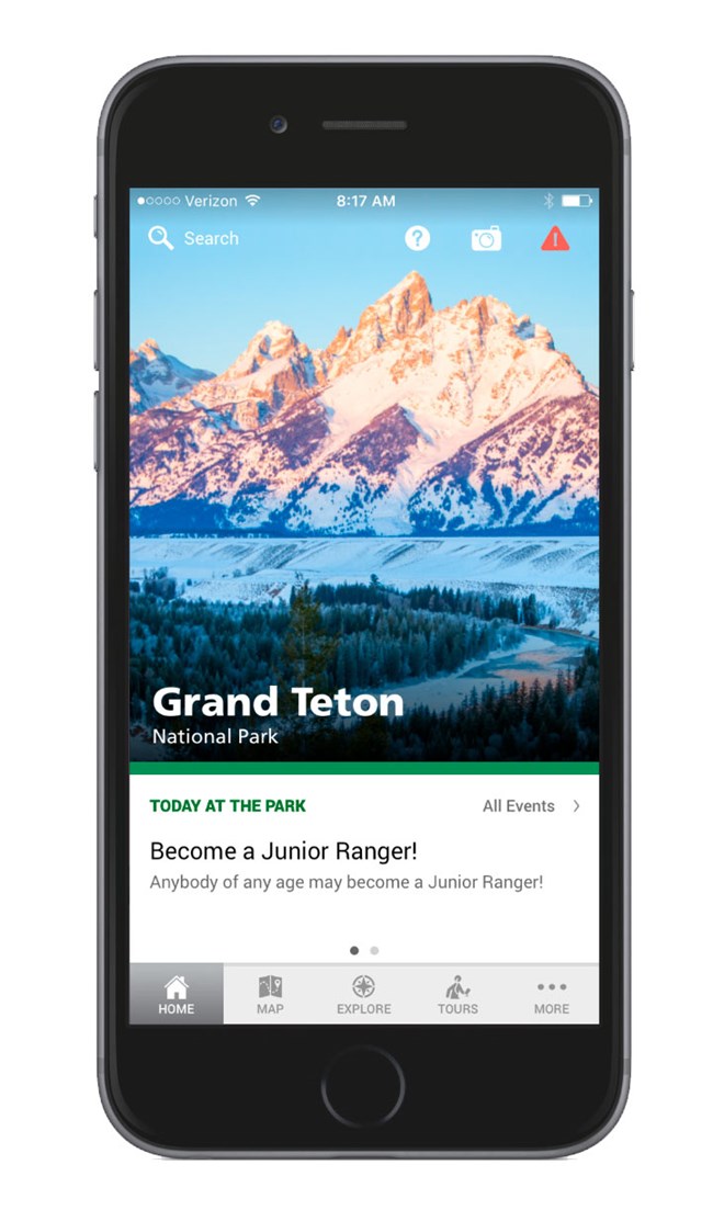 NPS Grand Teton App Grand Teton app home screen on smartphone. Home screen of app has image of craggy Teton mountains at sunrise with pink and light blue tones with the snake river in the foreground. An events box sits near the bottom with a button bar at the bottom.