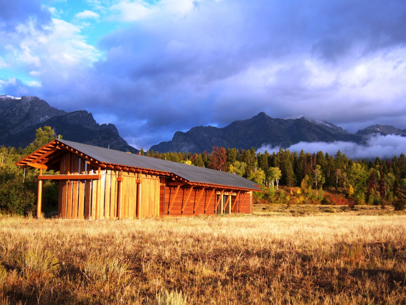 A wood building with mountains in the background.