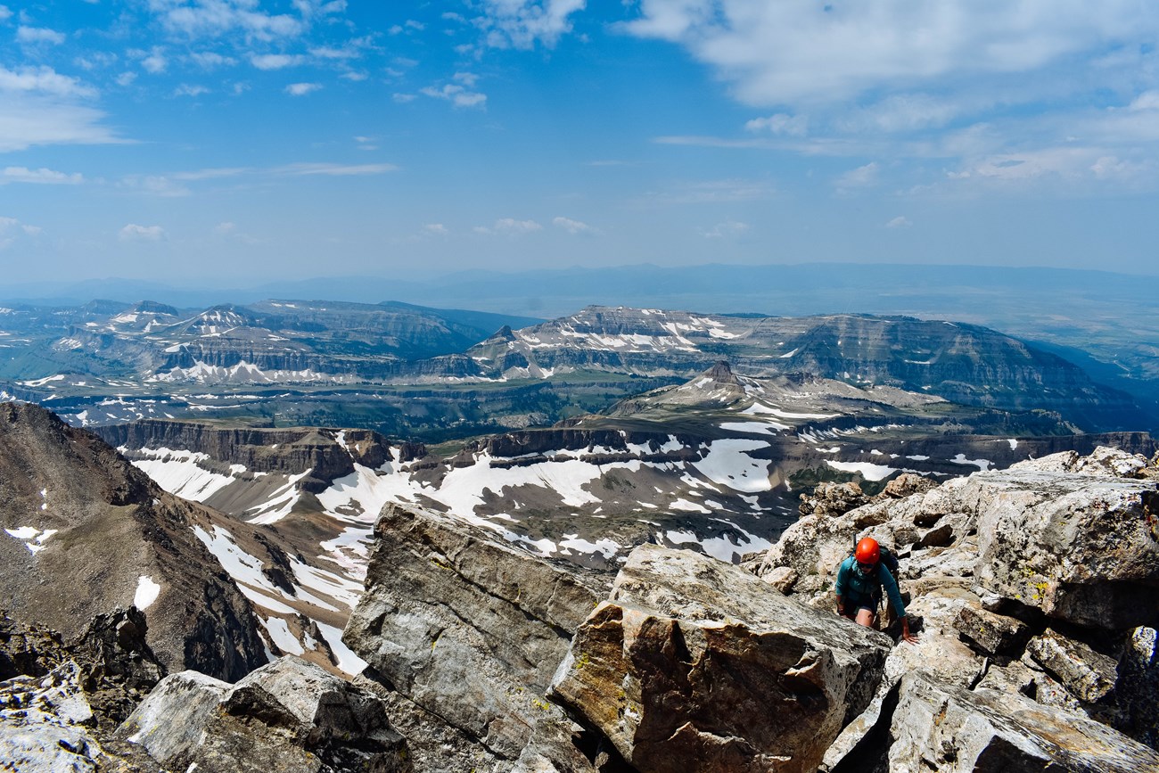 A climber travels across a rocky ridge.