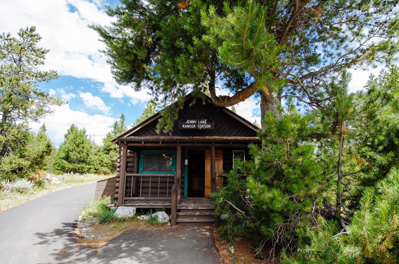 A log cabin with a sign reading "Jenny Lake Ranger Station".