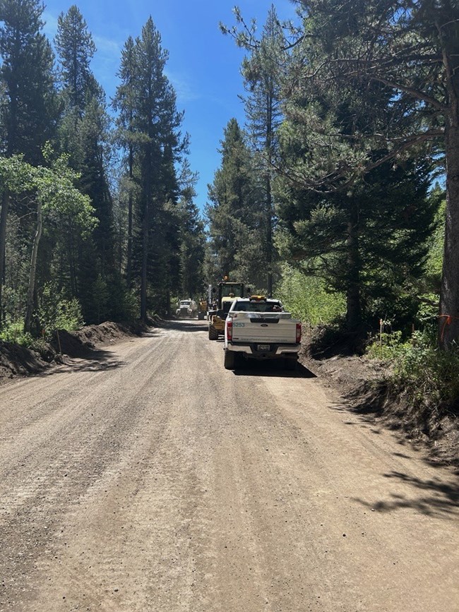 Dirt road with construction vehicles.