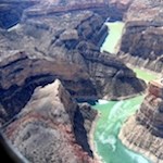 Aerial image of turquoise river flowing through a rocky canyon