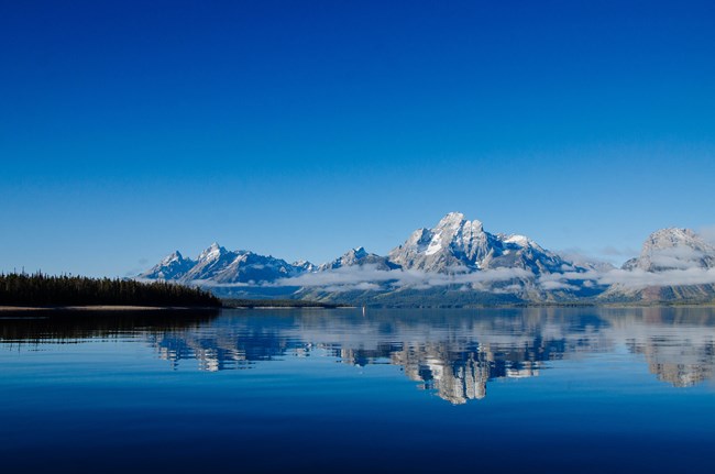 Mountains reflected on a calm lake.