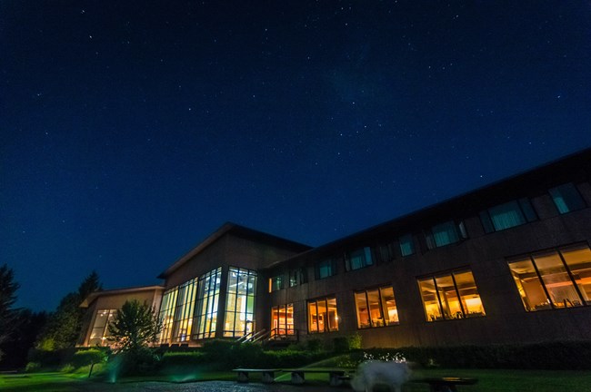 A building at night with windows lit up.