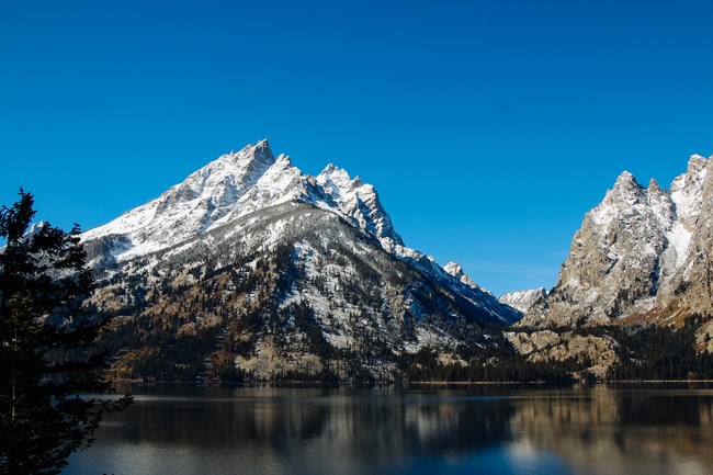 Mountains rise out of a calm lake.