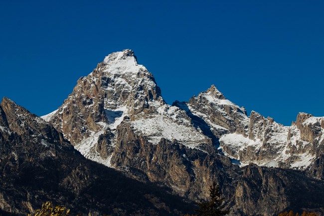 Mountains rise against a clear sky.