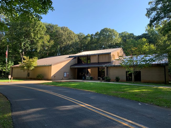 A large brown visitor center sits in the forest