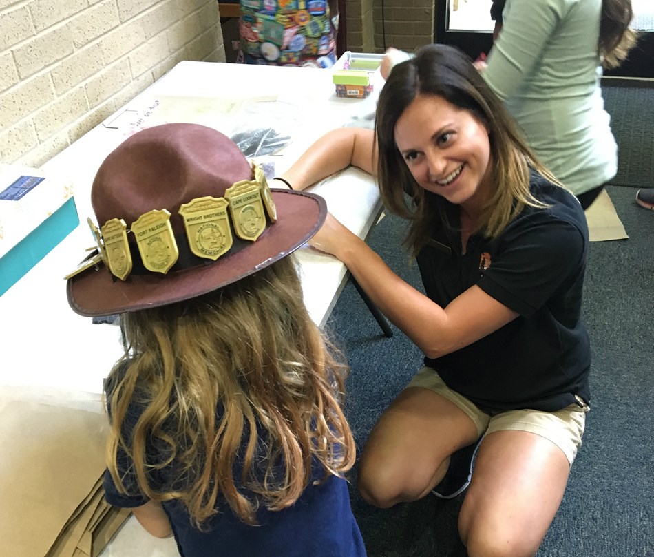 Smiling Volunteer works with a Junior Ranger on an activity book Smiling Volunteer works with a Junior Ranger on an activity book