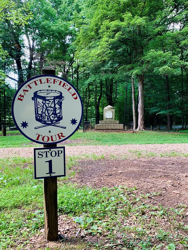 A tour sign in front of a monument