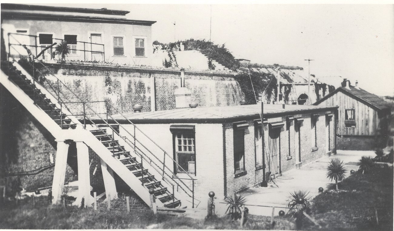Historic black and white image of a one-story brick building.