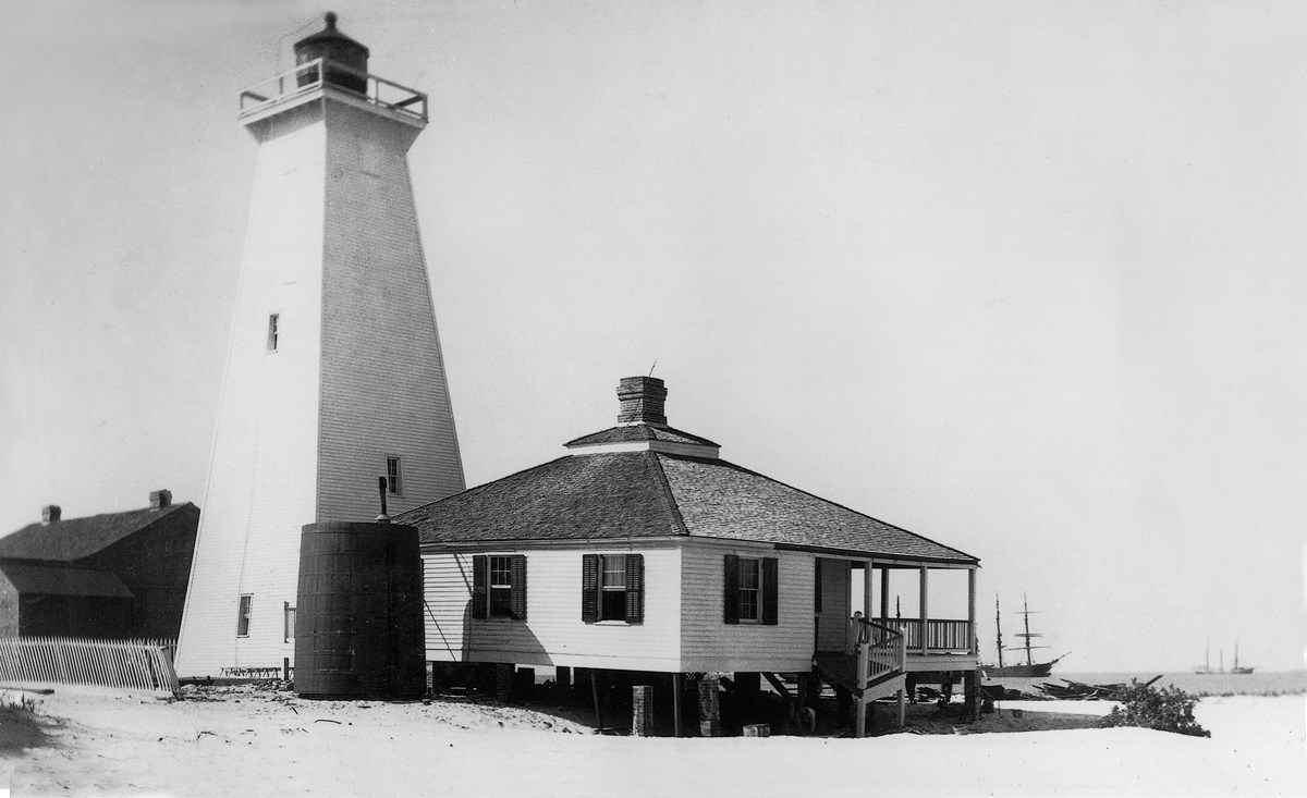 Black and white photo of the second Ship Island Lighthouse and one story keepers quarters.