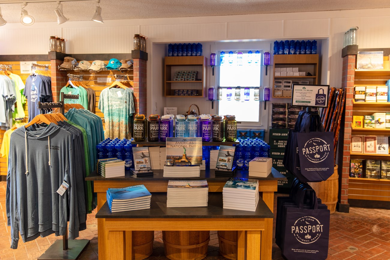 An array of books, t shirts, and other products stands in a bookstore.