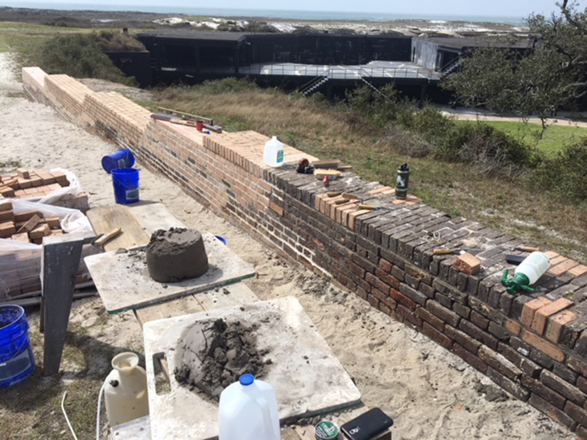 Pickens Preservation Tools, equipment, and supplies lie near a newly completed breast-high wall.