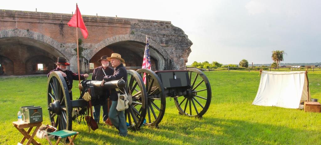 CivilWarOnSantaRosaIsland Three men in blue Civil War uniforms stand around a cannon of the same period.