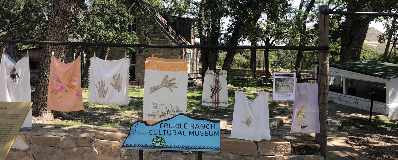 Vintage clothes are attached to a ranch fence by clothespins.