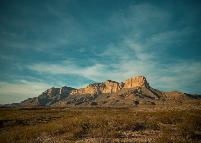 A mountain range rises suddenly above the desert floor