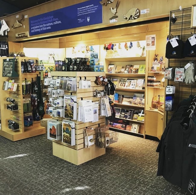 an image of the park book store, lit up and filled with displays showing off various knick knacks like books, posters, and postcards.