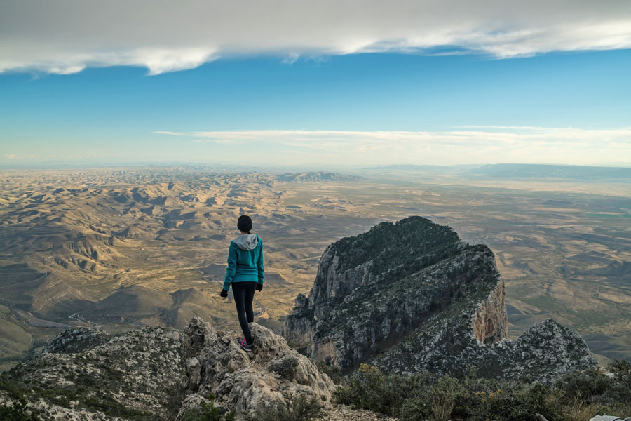 Hiker near the top of Guadaloupe peak, looking down on El Capitan and across the horizon