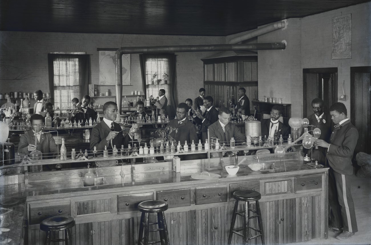 George Washington Carver in a lab classroom with Tuskegee Institute students.