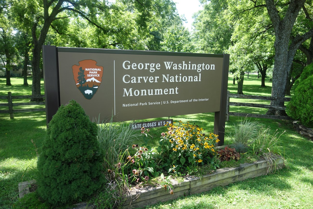 Park entrance sign with wildflowers.