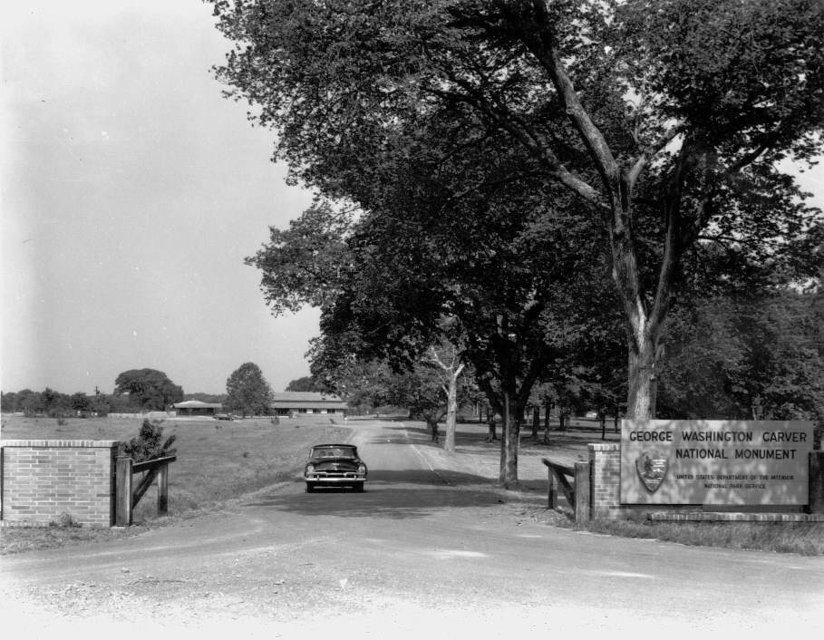 A car leaving the park with the entrance sign in view.