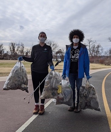 Two volunteers with full bags of trash on the Mount Vernon Trail