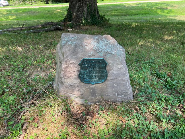 A plaque attached to a stone.