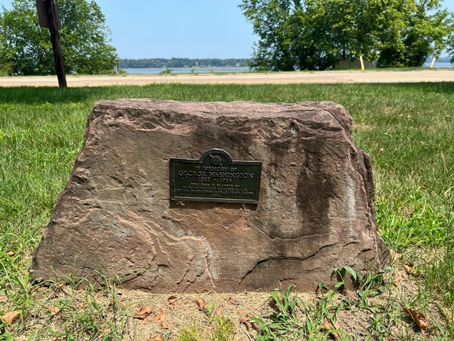 A plaque attached to a stone.