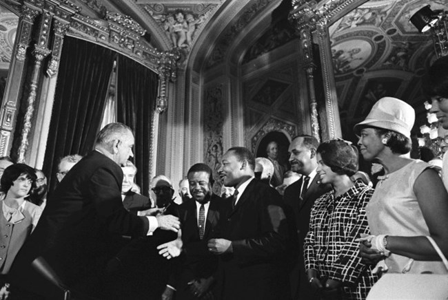 President Lyndon B. Johnson gives pen he used to sign the Civil Rights Act to Dr. Martin Luther King, Jr., August 6, 1965. (Lyndon B. Johnson Presidential Library, National Archives)